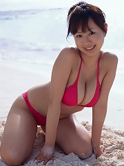 Cute asian babe showing off her tits at the beach in a bikini