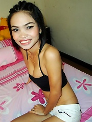 Smiling Thai model posing nude on a bed